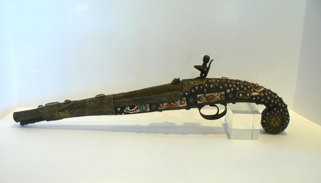 This coral, silver and turquoise adorned two-stage barrel flintlock pistol is a handsome example of 18th c. Turkish craftsmanship and the earlier use of semi-precious gems in weaponry. For the pistol connoisseur, a nice complement to a collection.