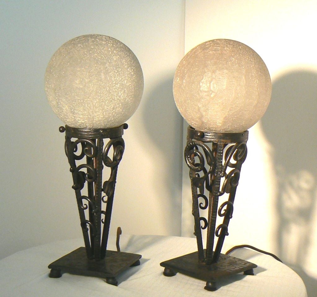 Charming pair of smaller profile Art Deco lamps. Nice weight to both brass base and globe; very subtle crescent etching in the base. Toggle switch electrified.<br />
<br />
Weight/thickness of glass provides soft glow.