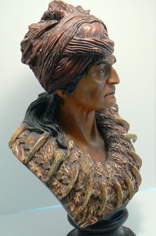 Striking bust of the famous Geronimo (1829-1909)in red turban and adorned with bear claws, gold and silver coin necklace. Quite impressive in its realism and warrior expressiveness.
