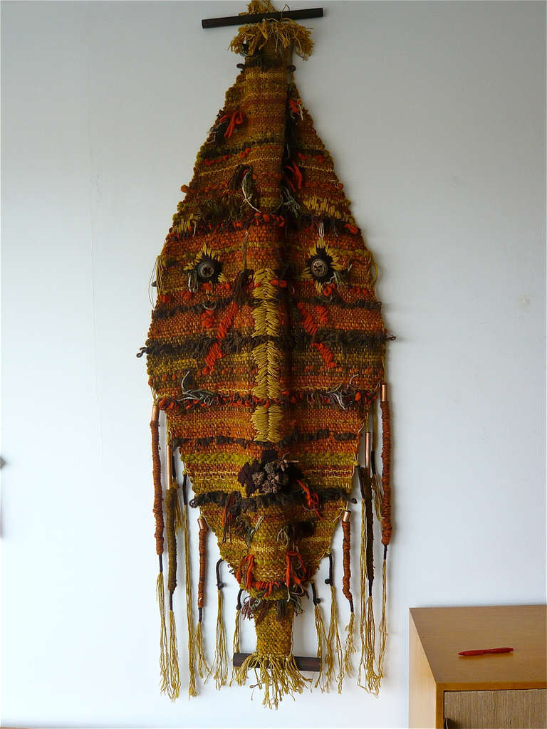 Unusual,colorful weaving in the shape of a tribal mask using wool,ceramics and copper tubing.Signed and dated 