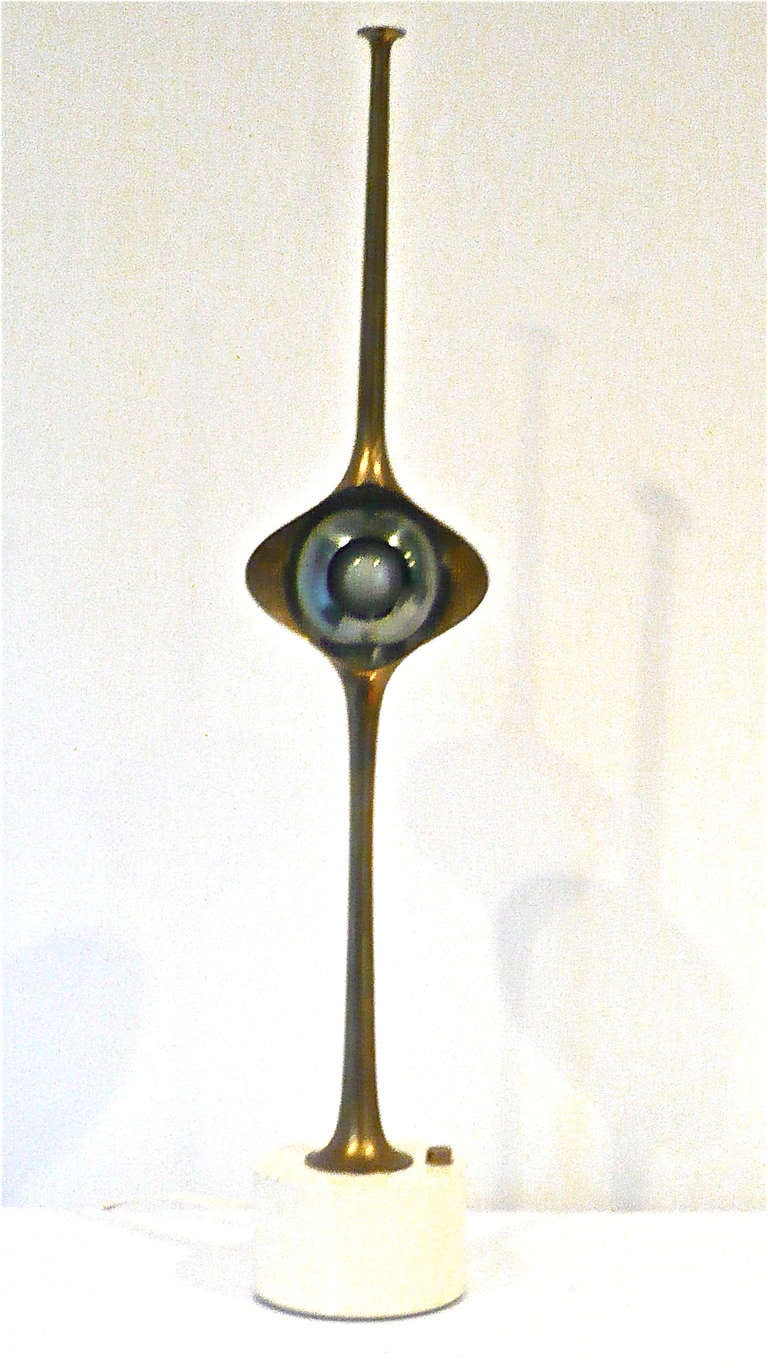 Original Arredoluce eyeball lamp, brass body with a gun metal grey swiveling.magnetized eyeball, mounted on a white enameled base.Direct or indirect lighting.