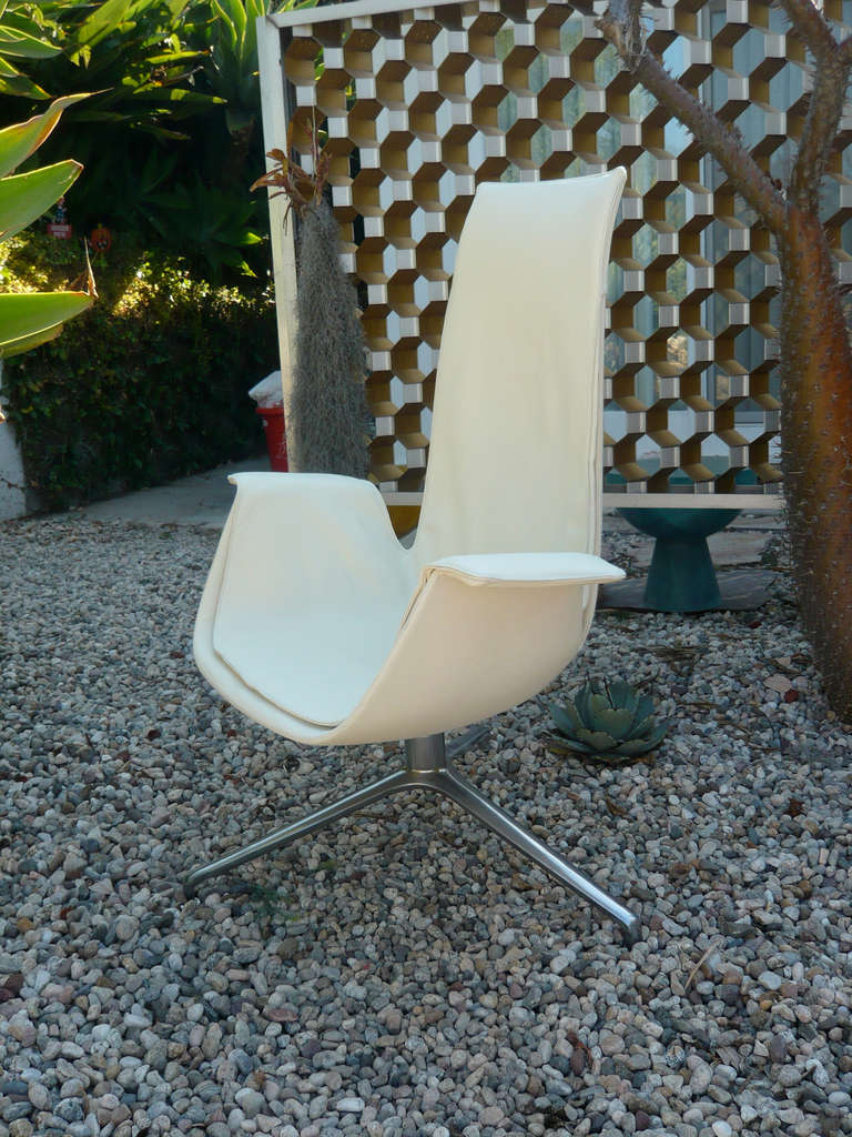 Steel plate wrapped in cream white leather on tripod aluminum base with 360 degree swivel. The thin steel plate back flexes making for a very comfortable chair.