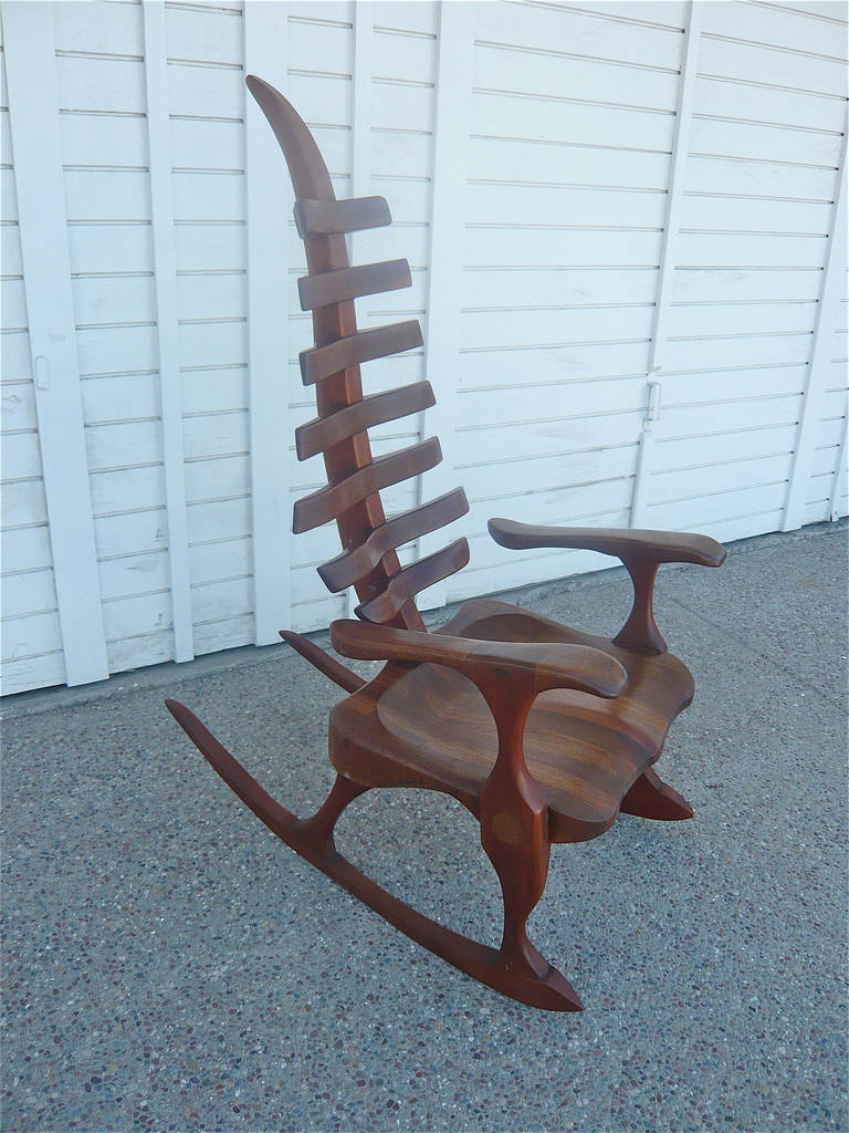 African American woodworker,James Camp,was a self-taught craftsman working out of his studio in Philadelphia,Pa. in the 70's and 80's.This spine-backed rocker was carved and sculpted out of walnut,etched and signed 