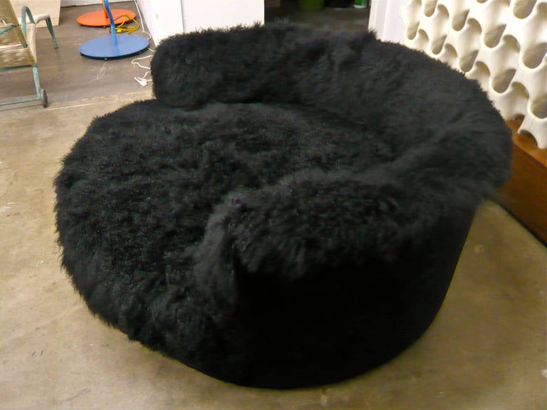 Equally at home in an Aspen lodge or Manhattan penthouse. Covered with plush black Tibetan long-haired sheepskin over soft foam and wrapped in black suede.  This re-invented 1960s love seat invites snuggling, lounging or whatever. Comfortably seats