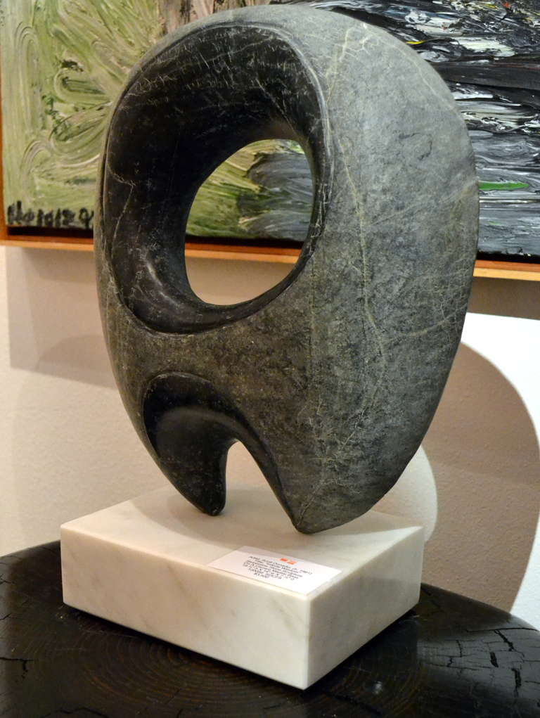 Artist Scott Donadio (b. 1961) hand carved serpentine stone in an eye pleasing infinite form and finished the look off by placing it upon a white Carrera marble base.  Note the textural quality to the serpentine on the area outside the rounded form.