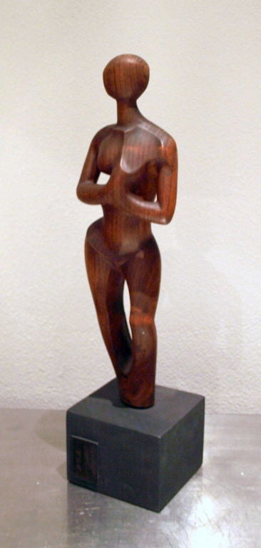 This sculpture of an abstract female figure has been delicately carved from wood and signed by the artist on a raised plaque affixed to the ebony wood painted base.   <br />
<br />
The wood figure measures 15.5” high and the base 3.5” high, giving