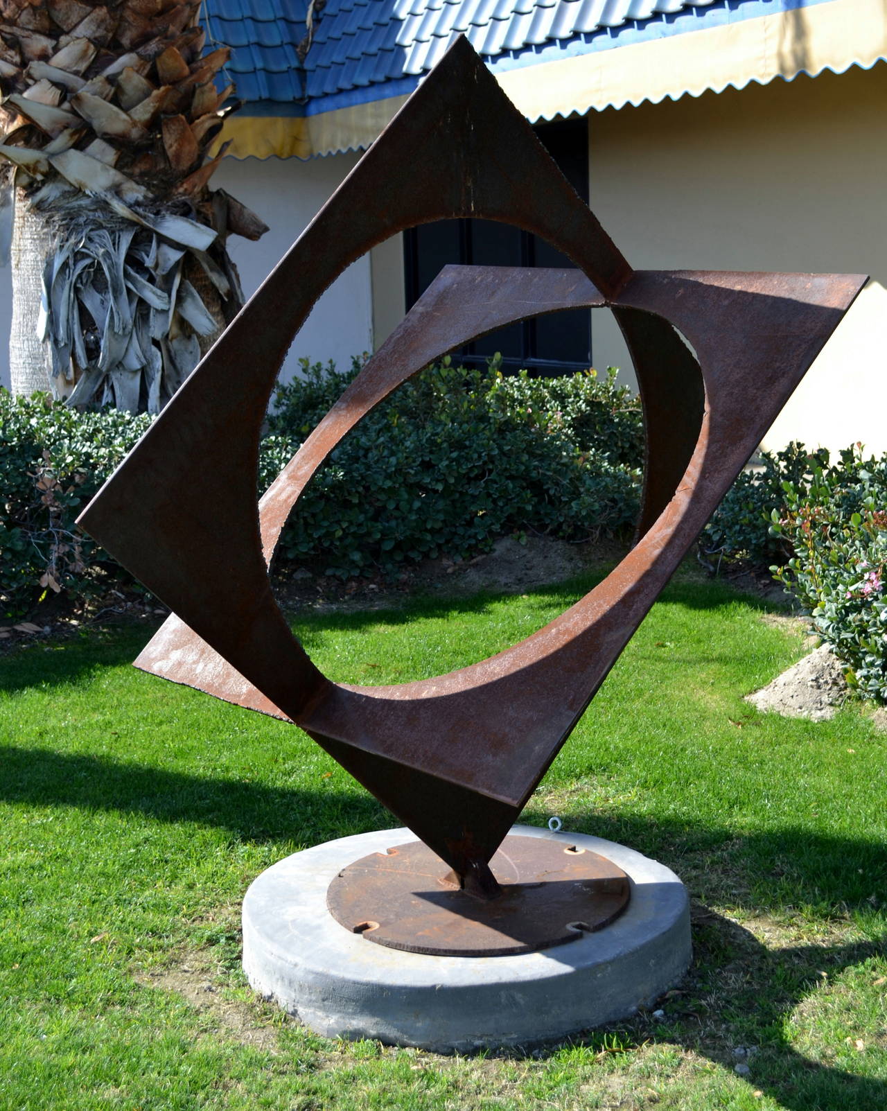 Artist Simi Dabah (b. 1927), created this abstract sculpture that is comprised of two steel plates, with round center cutouts. The artist welded the plates in such a manner as to reflect the interlocking of squares, thereby also creating the