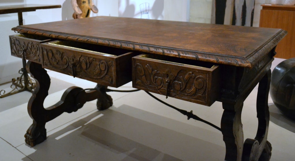 Together with claw feet, wrought iron stretcher bars between the legs and heavy carvings and scroll work help give this period piece much significance.  There are three drawers fitted to the one side,so it works perfect as a desk or sofa table.