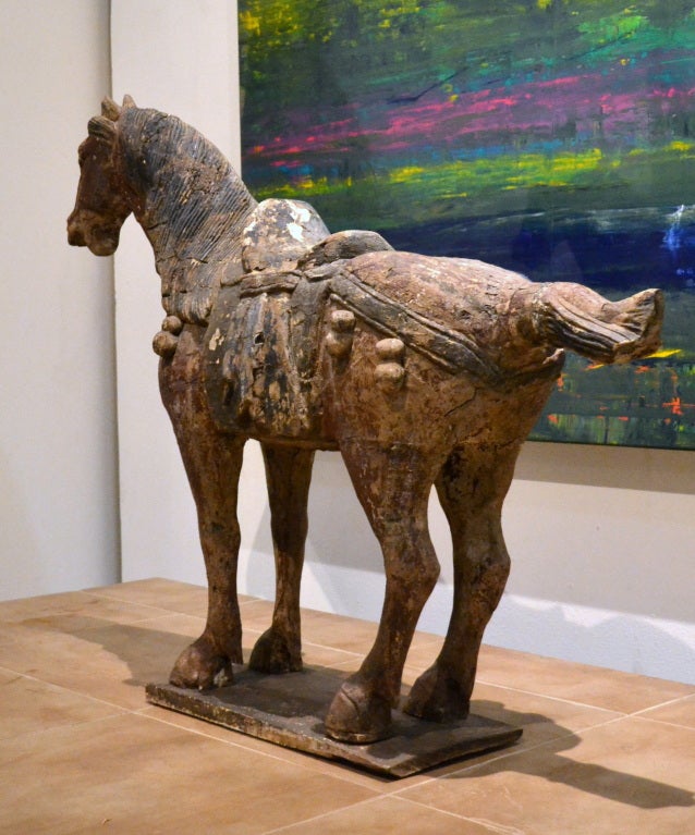 Distressed Chinese paint decorated carved wood horse with wonderful aged patina.  Large in scale and clearly it makes a rich and powerful statement wherever it is placed and standing 33