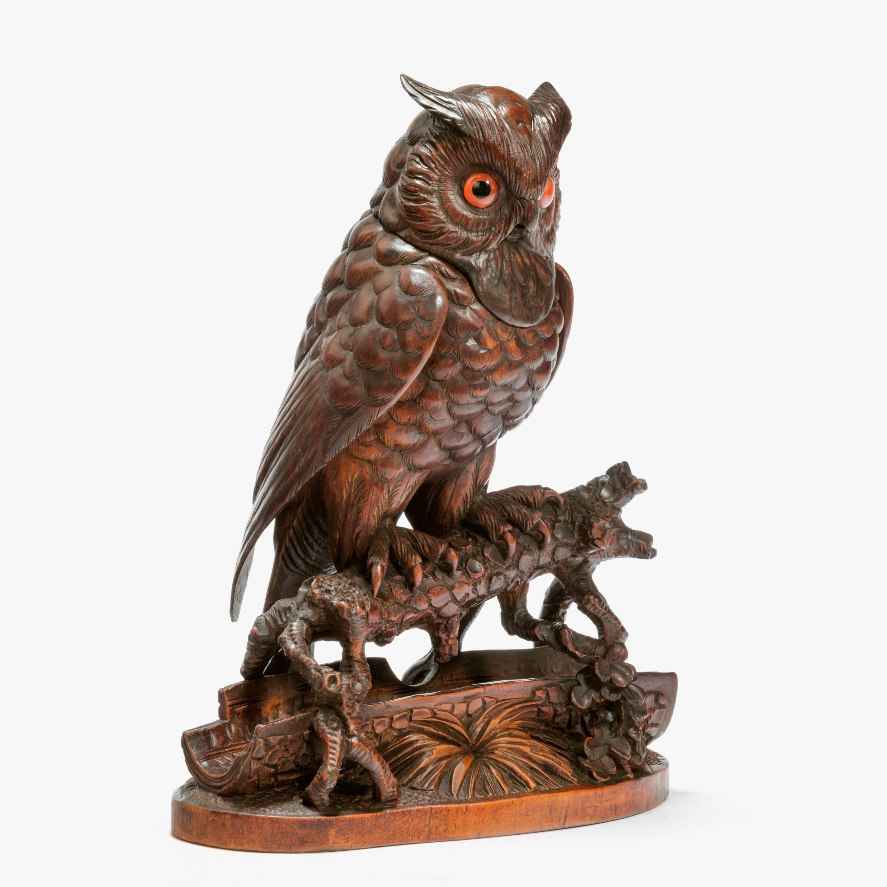 In the form of an owl with a hinged head and glass eyes.