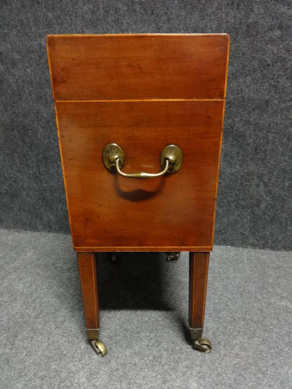 A very good Georgian mahogany cellaret, inlaid to all sides with boxwood, with a boxwood lozenge escution, sectioned for six bottles with brass carry handles and brass cup castors, original lock with key, and in excellent original condition.