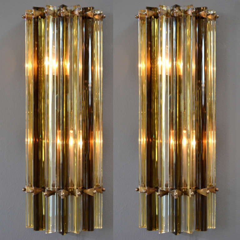 Beautiful pair of Murano glass sconces by Venini with alternating prisms in amber and dark tea colored glass, on a patined brass structure. Rewired for the US.