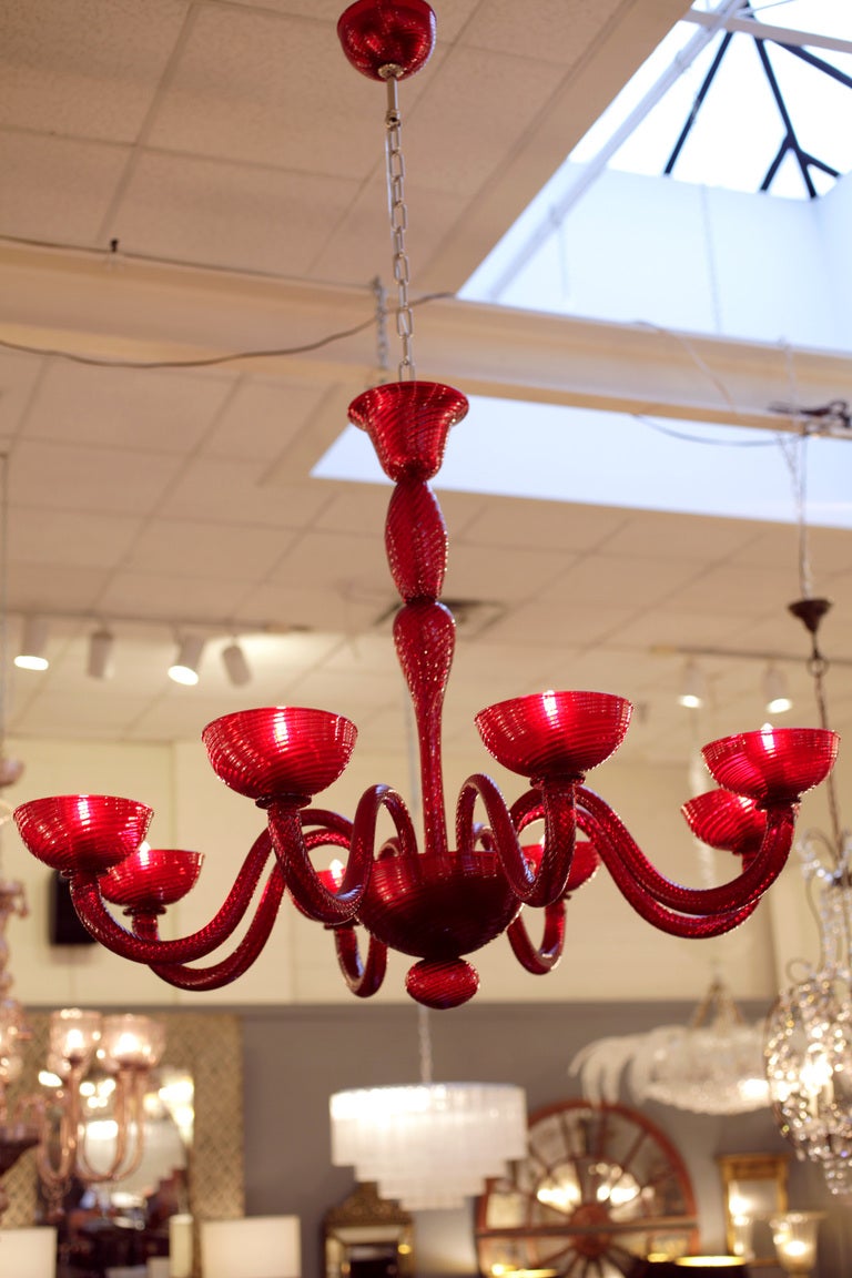 A striking hand blown Murano glass chandelier in a bold ruby red. 8 branches, rewired to US standards. Height including chain and matching glass canopy is 52.5 inches. THIS will definitely create the wow effect, beautiful deep red will vibrate in