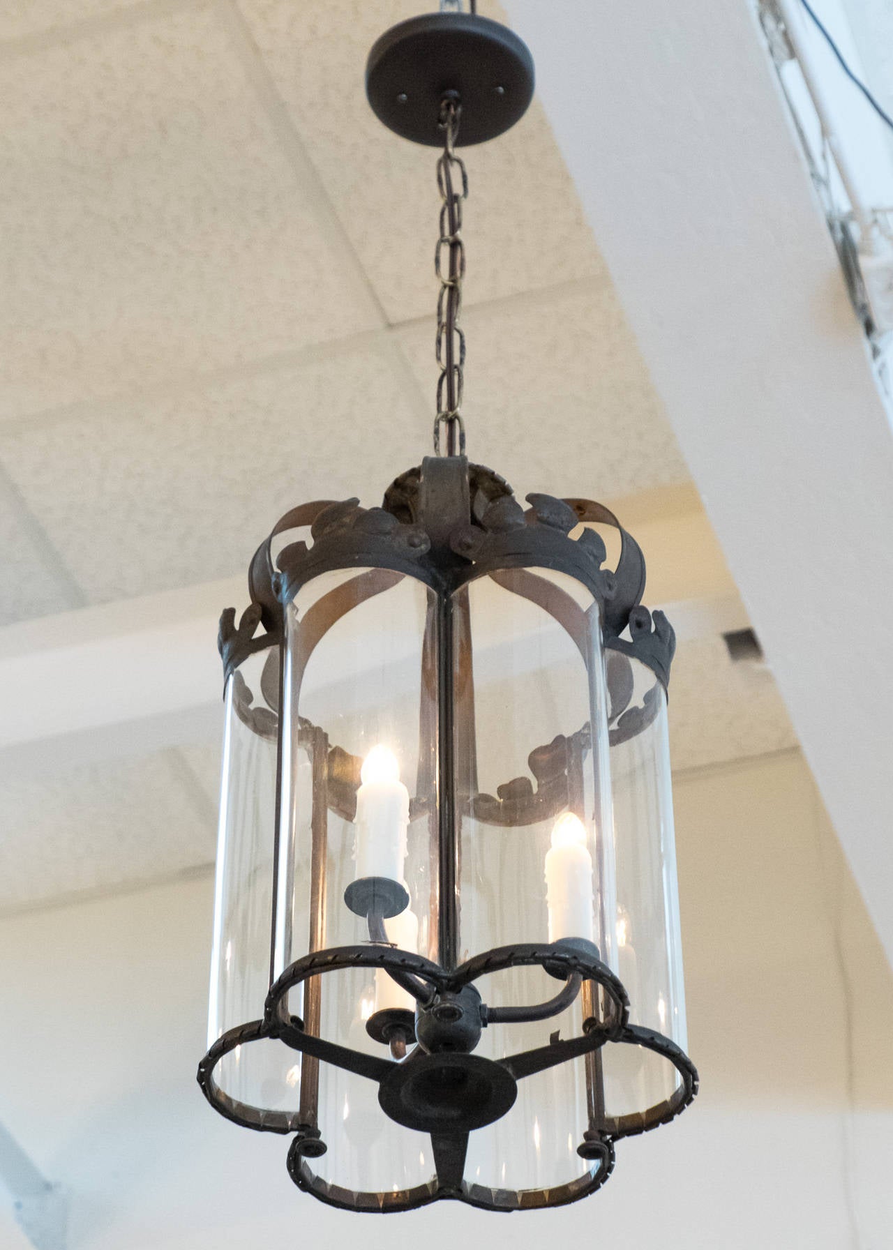 Superb French antique lantern in patinated brass and curved antique glass, newly electrified with a three candelabrum cluster. We love the unique shape and curved glass. Height including chain and canopy is 35.25 in.