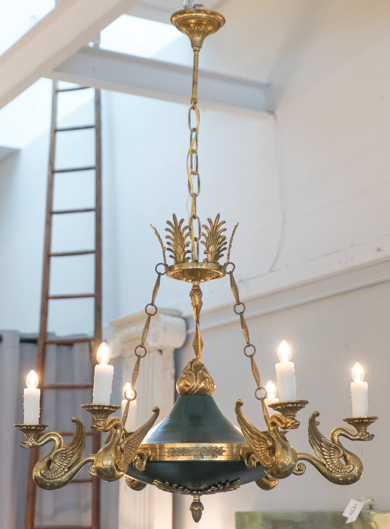 Rare French Empire style gilt bronze and (dark green) tole chandelier with six branches featuring flying swans details, floral and acorn cast details, and matching canopy with decorative chain. The quality of the castings and ormolu are simply