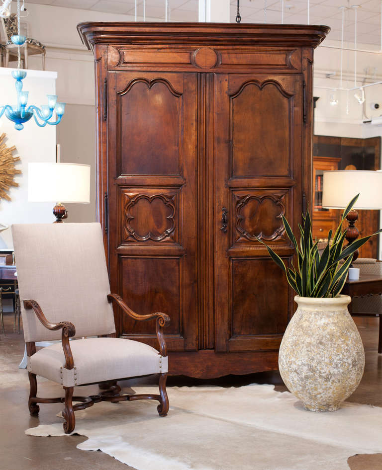 French Louis XIV period armoire in solid, hand-carved walnut. From the mid-17th century, Lyon has been the capital of silk harvesting and manufacturing; the precious bolts highly praised by Tuscan merchants were purchased from the French silk