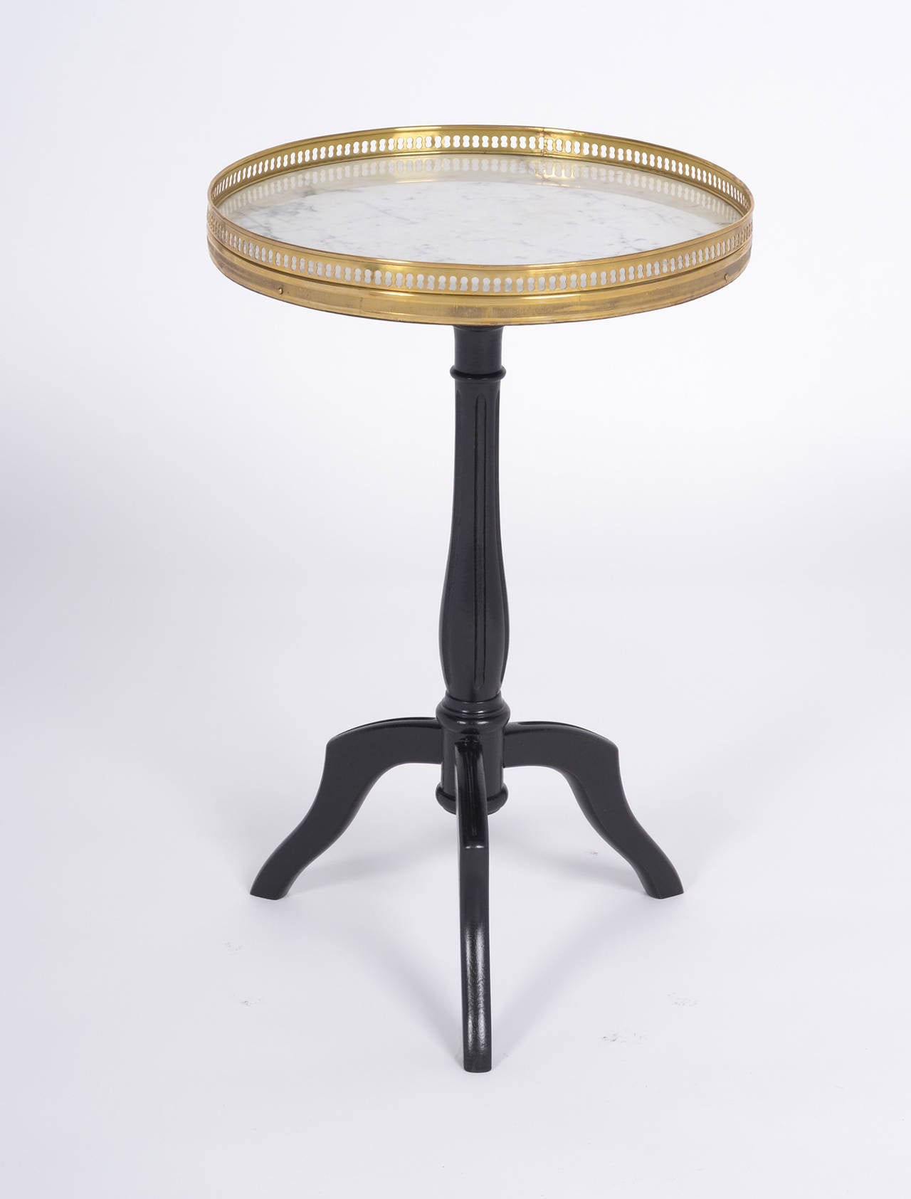 French Louis XVI style side table. Carrara marble top is surrounded by a finely cast brass gallery, supported by an ebonized base finished with a lustrous French polish. The perfect occasional table in excellent antique condition.