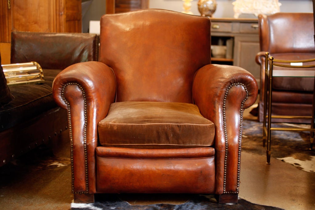 Bold and wonderful leather club chair in original patined Havana colored lambskin. Original Genoa velvet cushion in fair condition (down filling). All springs re-tightened, new webbing. Great style club chair, very comfortable.