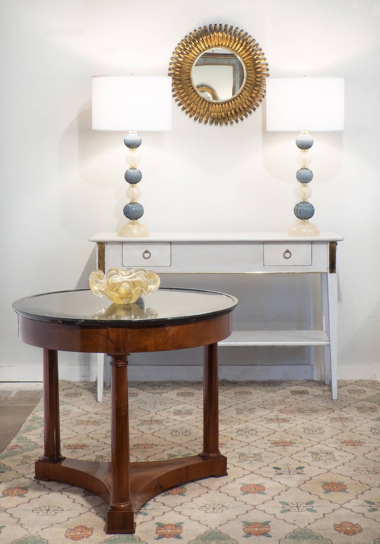 Antique French Directoire style console table in painted cherry with gold leaf details and brass trim. We love the angled legs and the great storage with two dovetailed drawers and bottom shelf.