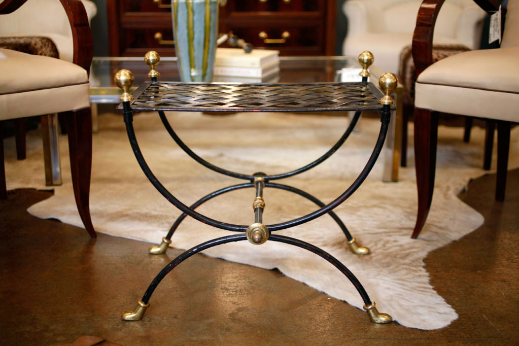 A sturdy and elegant vintage pair of black painted metal curule stools with brass details. Great neoclassical pieces with wonderful cast  brass work. We loved the stylized feet.