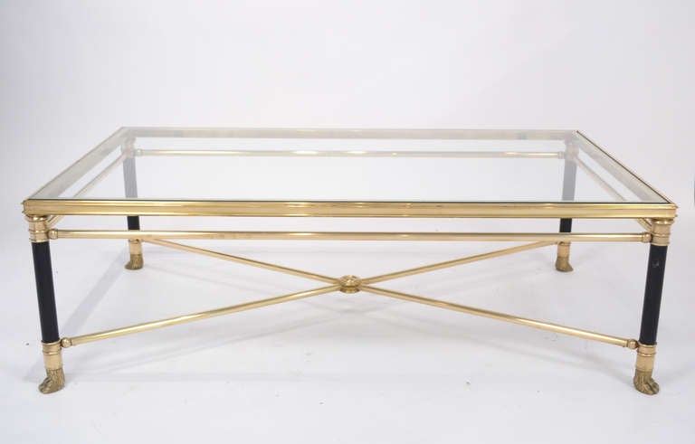 French Vintage coffee table by Maison Ramsay in gilt brass with finely cast bronze details, x-stretcher, and a glass top.
