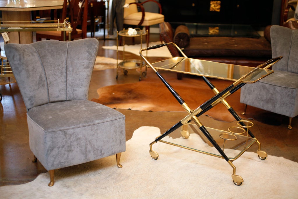 Italian Art Deco brass and ebonized wood bar cart with two glass removable shelves and brass bottle holder.
