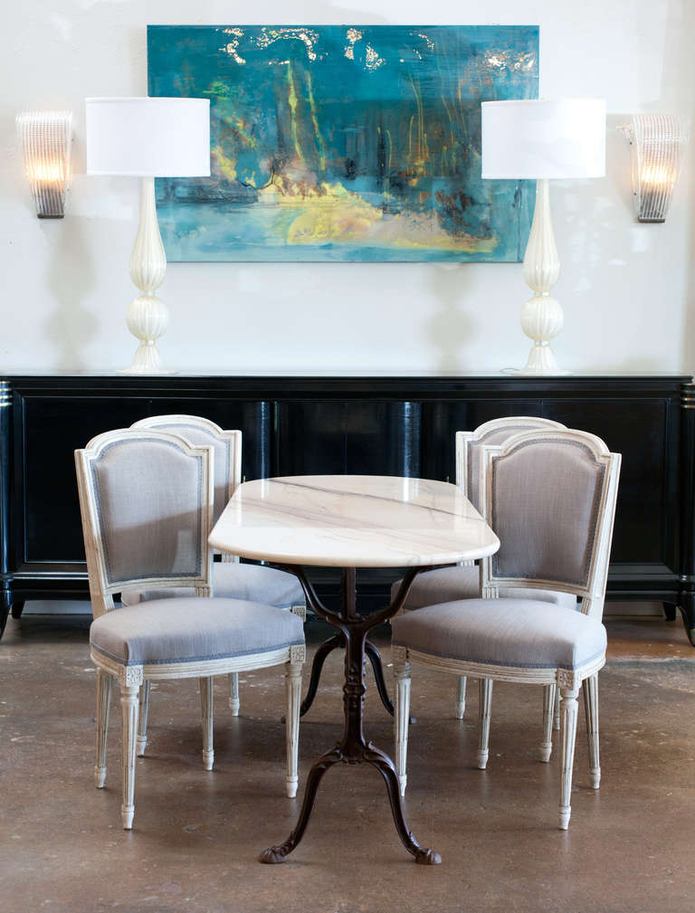 French antique bistro table with cast iron base and oblong Carrara marble top.