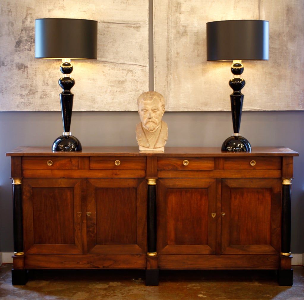 French antique Empire style buffet in solid walnut with ebonized columns and gold leaf details.Four  drawers with lost was bronze pulls.Interior shelves. We loved the clean lines and the versatility of this piece.