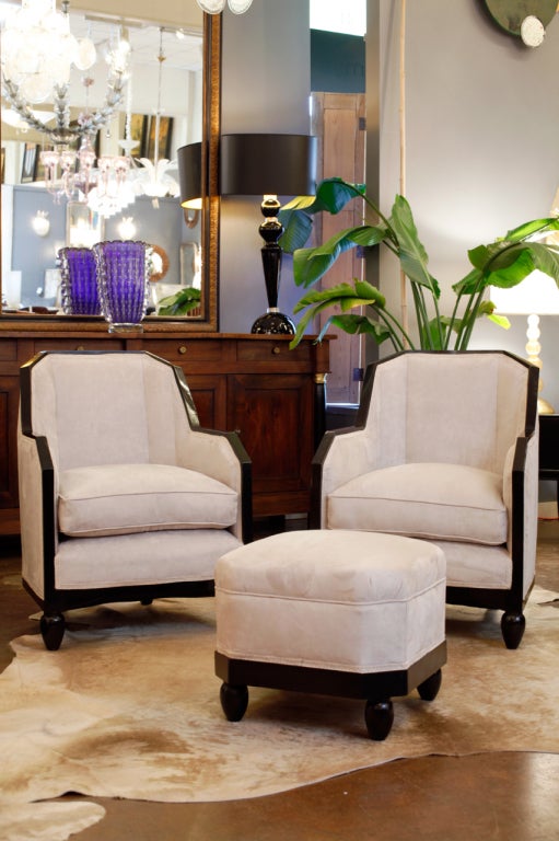 Pair of classic French Art Deco period armchairs with matching footstool, in the style of Pierre Chareau. Ebonized and French polished frames and feet. Recently reupholstered in a light velvet blend. We love the geometric lines and comfortable seats