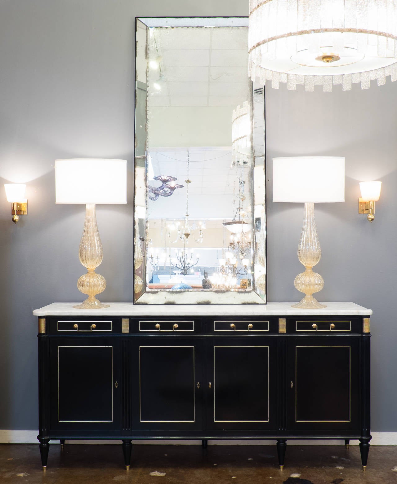 A stunning antique French Louis XVI style buffet/credenza in ebonized mahogany finished with a lustrous French polish, original intact Carrara marble top. Four dovetailed drawers and four doors with brass trim and hardware; polished mahogany