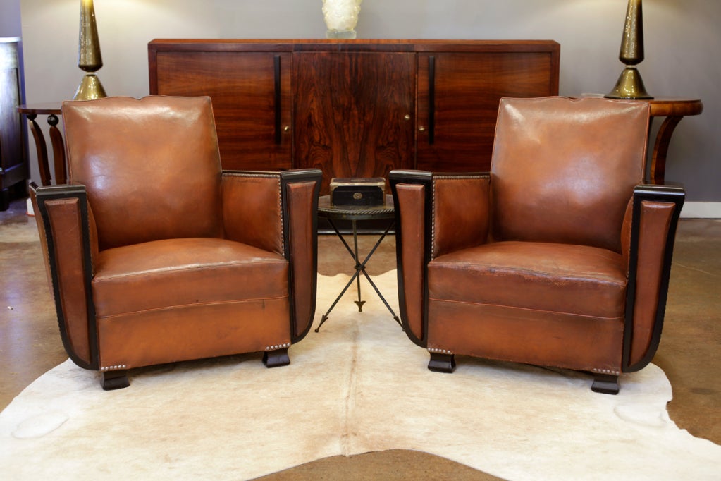 Fabulous pair of French Art Deco lambskin leather and ebonized walnut club chairs - all original. French polish finish on the armrests and feet. Seat height is 14 in.