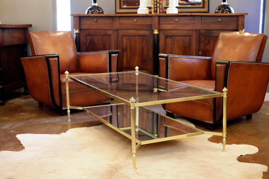 Beautiful vintage Maison Bagues coffee table in brass from the  Bank Santander in Madrid. Acorn finials, Finely fluted legs, clear glass top shelf, and antiqued mirrored glass bottom shelf. Gorgeous patina, a true classic.