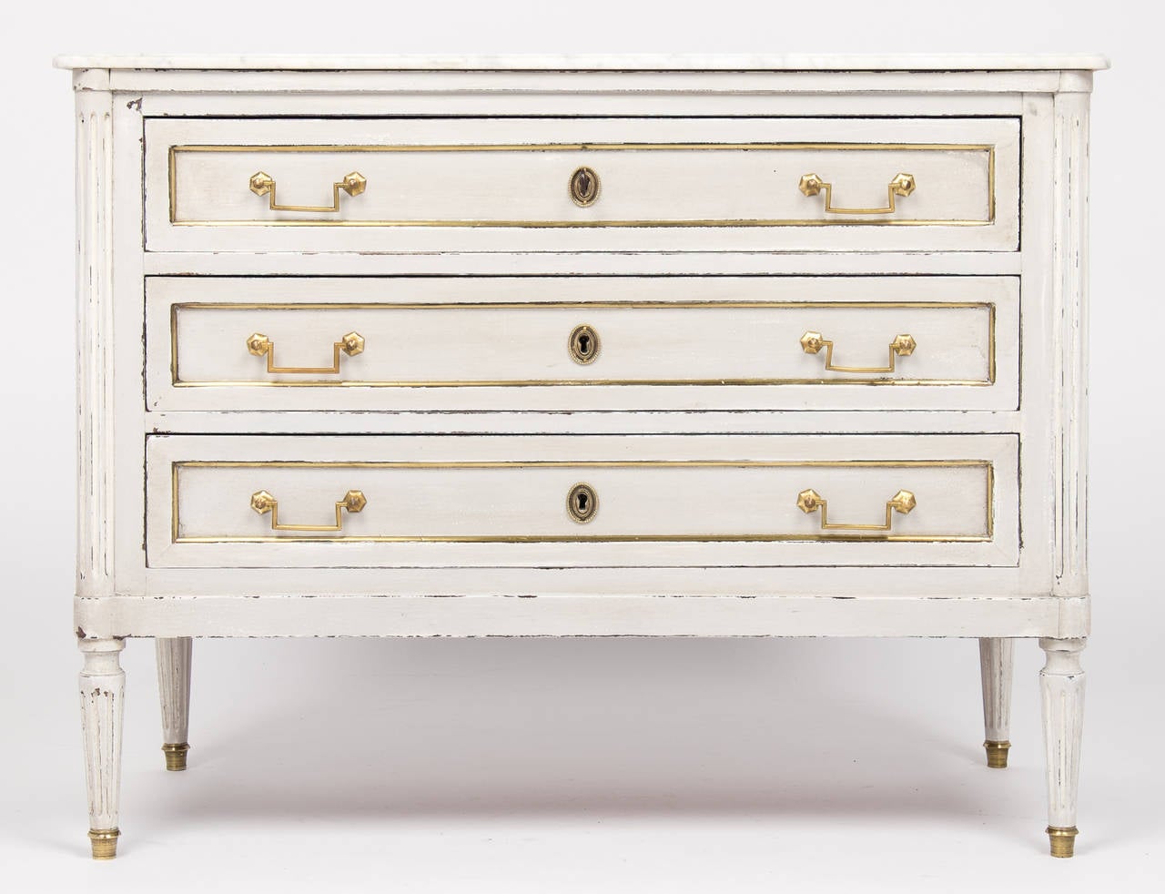 Louis XVI style hand-painted chest topped with beautiful Carrara marble. Three dovetailed drawers, brass trim on all sides and fluted legs. A charming French antique chest.