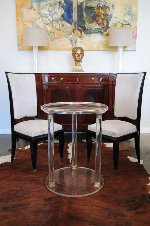 French vintage side table in lucite. Three columns capped with finely cast and gilded bronze.