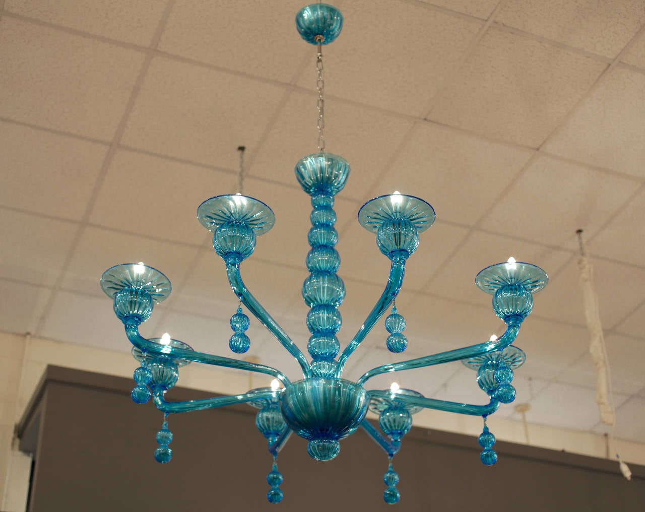 Handblown Murano glass chandelier in aquamarine with eight branches and hanging pendants. Eight candelabra lights, rewired to US standards. Height including chain and matching glass canopy is 60 inches. Another flawless design by Barbini, circa