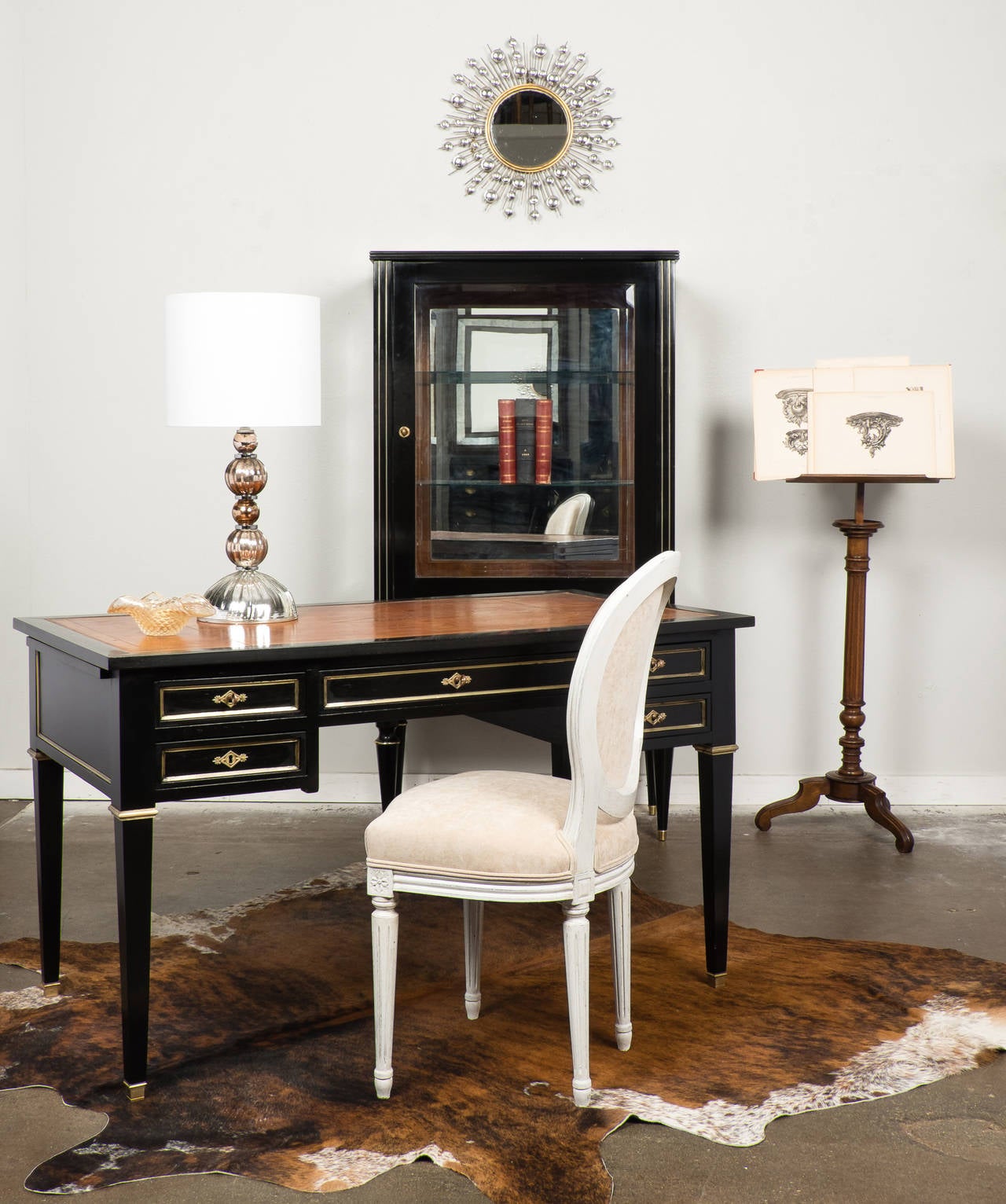 French Directoire style desk in ebonized mahogany with a lustrous French polish finish, fine brass trim, and beautiful embossed tan leather top. Five dovetailed drawers and two leather topped pull-out writing shelves. The back is finished in faux