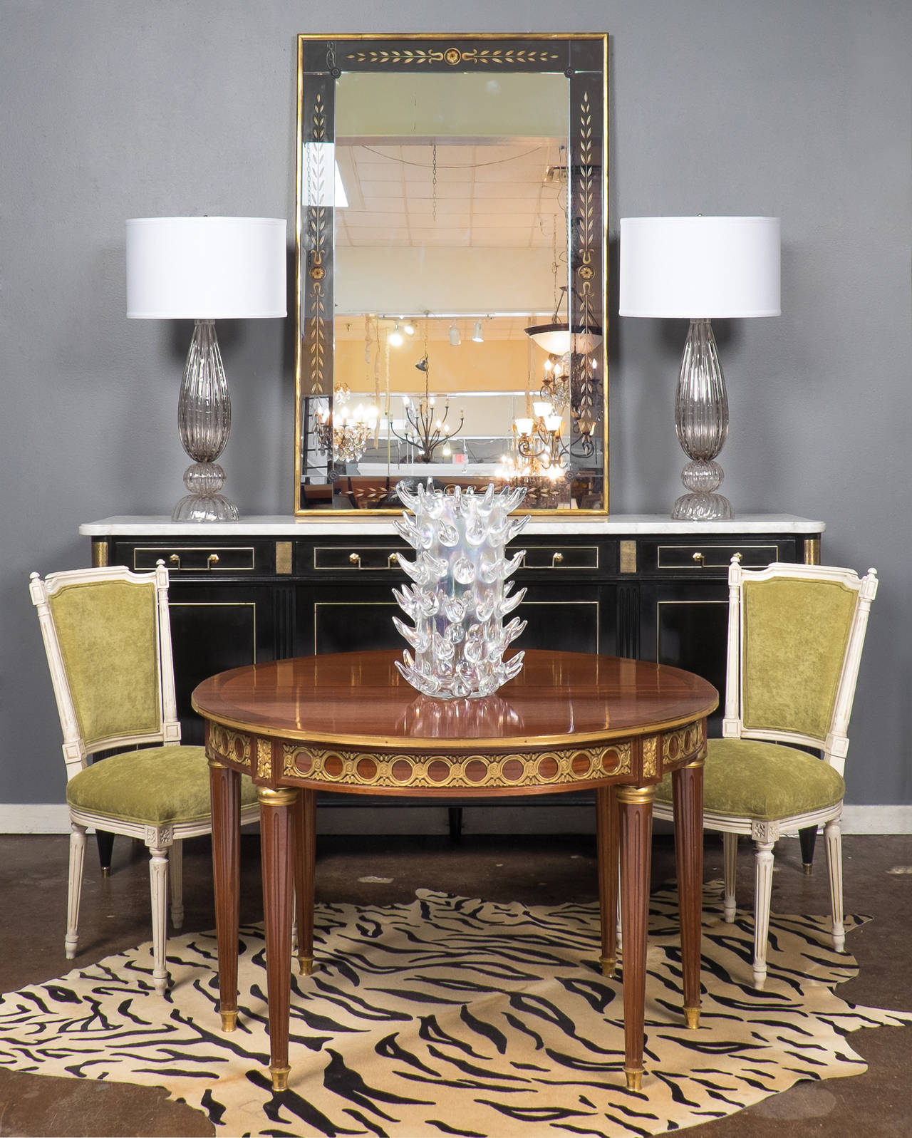 French Louis XVI style table in French polished mahogany with finely cast ormolu décor and fluted, tapered legs. A beautiful demilune console table when closed, this versatile piece opens to a full circle, perfect for a small gathering with dinner