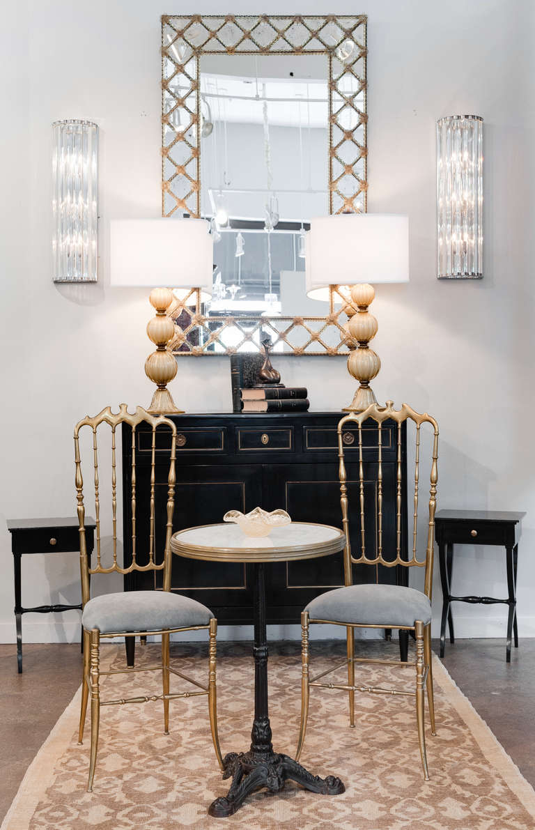 Fine French Directoire style side tables in solid mahogany, ebonized and French polished, with marble tops and curule shaped bases. Each table has a single dovetailed drawer with brass pull. A lovely pair that shows the beauty is in the details.