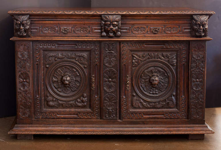 Amazing French Second Empire buffet of solid oak in the manner of Hugues Sambin, richly hand-carved details of fauns, lion's heads, friezes, garlands, and sunbursts. This unique piece was created at a time when the mystery and romance of the