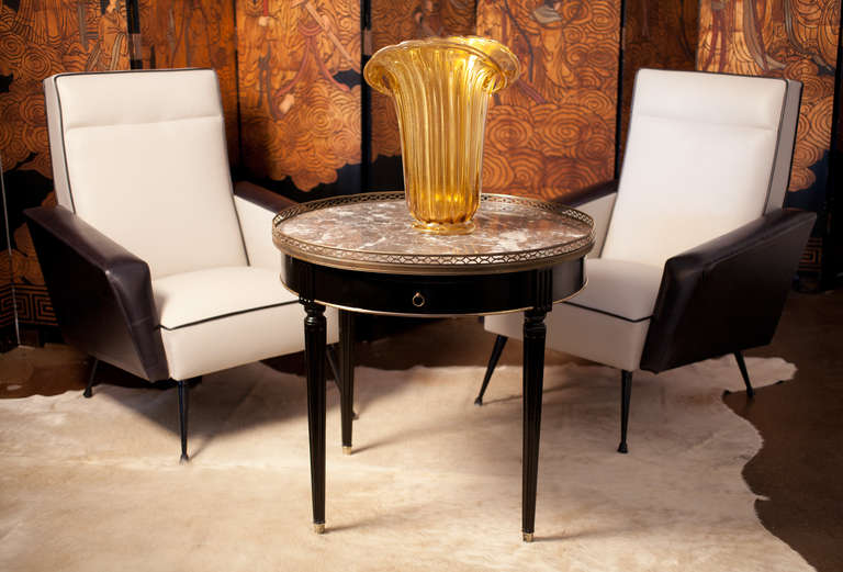 French Louis XVI style bouillotte table with brass trim, gallery, and feet. Beautiful gray Saint Anne marble top with white veining. Two dovetailed drawers, two embossed and gilded  leather top shelves, fluted legs, French polish finish.