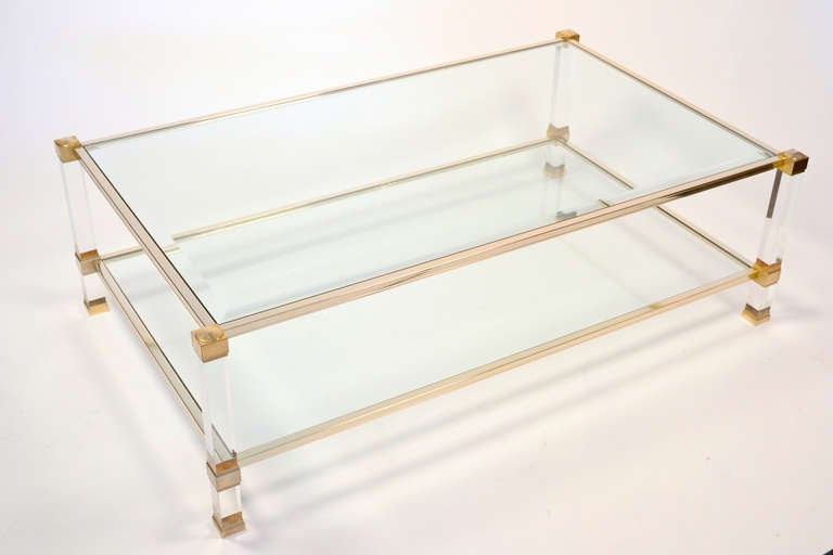 Large French vintage coffee table by Pierre Vandel in gilt brass and lucite with beveled glass top and glass bottom shelf. Signed Pierre Vandel Paris.
