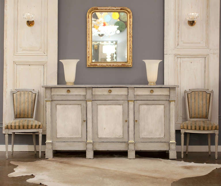 Antique French Directoire style buffet in solid walnut with blue/gray patina finish and gold leafed accents on four pilasters. Three dovetailed drawers with bronze pulls and three compartments with locking doors and interior shelves. Great