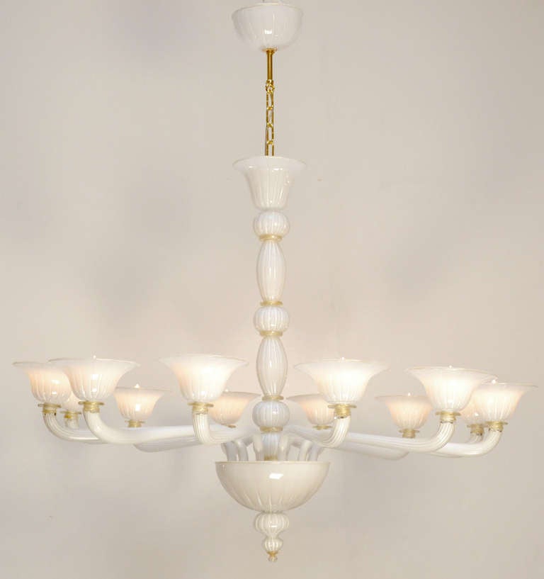 An ethereal handblown Murano glass chandelier in translucent white with gold flecked rings and finial, by Barbini. Each of the 12 blossoming bobeches is also rimmed with gold leaf flecks. This beautiful work of glass and light has been rewired for