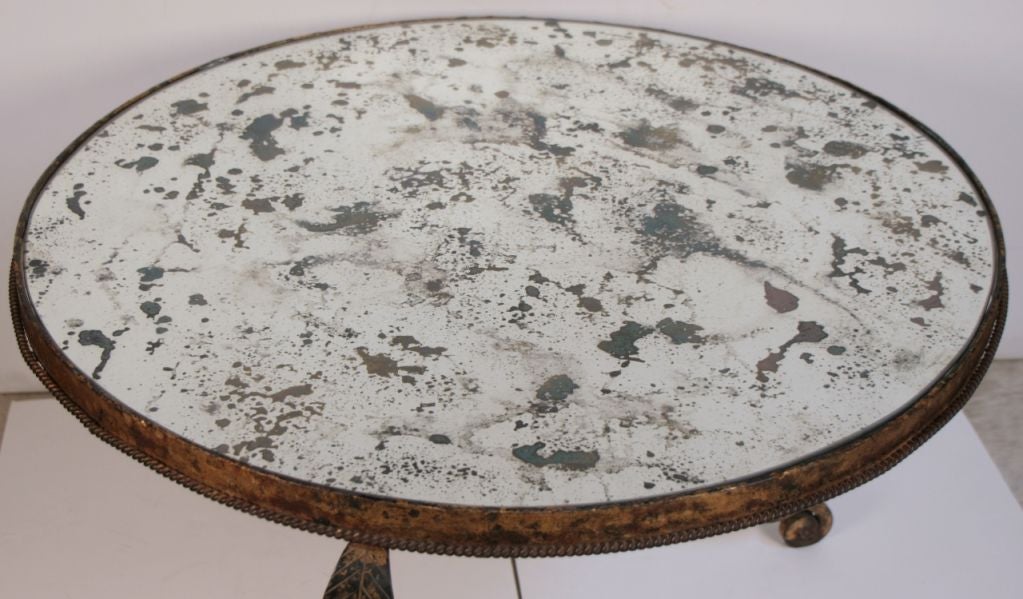 Beautiful Spainish Art Deco period coffee table in hand hammered forged iron, gold leafed, antiqued mirrored glass top.
