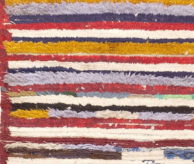 Contrasting stripes with discontinuous color segments rendered in bold, bright colors decorate the brilliant field of this vintage Mid-Century rug from Morocco. This charming Moroccan rug features a vivid combination of solid stripes paired with