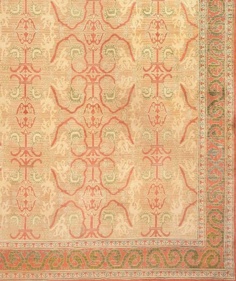 Ferny greens, warm brick reds and posh neutral tones are juxtaposed beautifully in this masterful antique Spanish carpet. This palace-sized creation exhibits a refined allover pattern that displays recurving Persianate arabesques with elegant