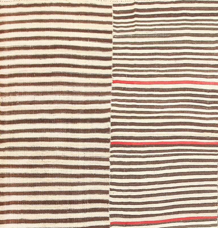 Truly ahead of its time, this antique Mazandaran kilim is a superb example of provincial minimalism that inadvertently and unintentionally conforms to modern design principles. Through simple techniques and fundamental stripe patterns, Mazandaran
