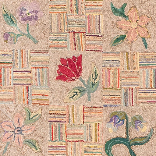 Beautifully composed and executed, this charming antique American hooked rug depicts an elegant assortment of red roses, woodsy blossoms, pansies and ephemeral spring flowers. Delicately shaded petals and decorative leaves that feature soft