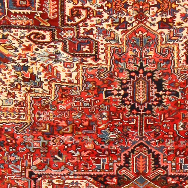 Vintage Persian Heriz rug, circa mid-20th century, here is an intricate Persian Heriz rug featuring a large-scale geometric medallion, throughout which many spiritual and regenerative symbols appear. Brilliant crimson dominates the color scheme of