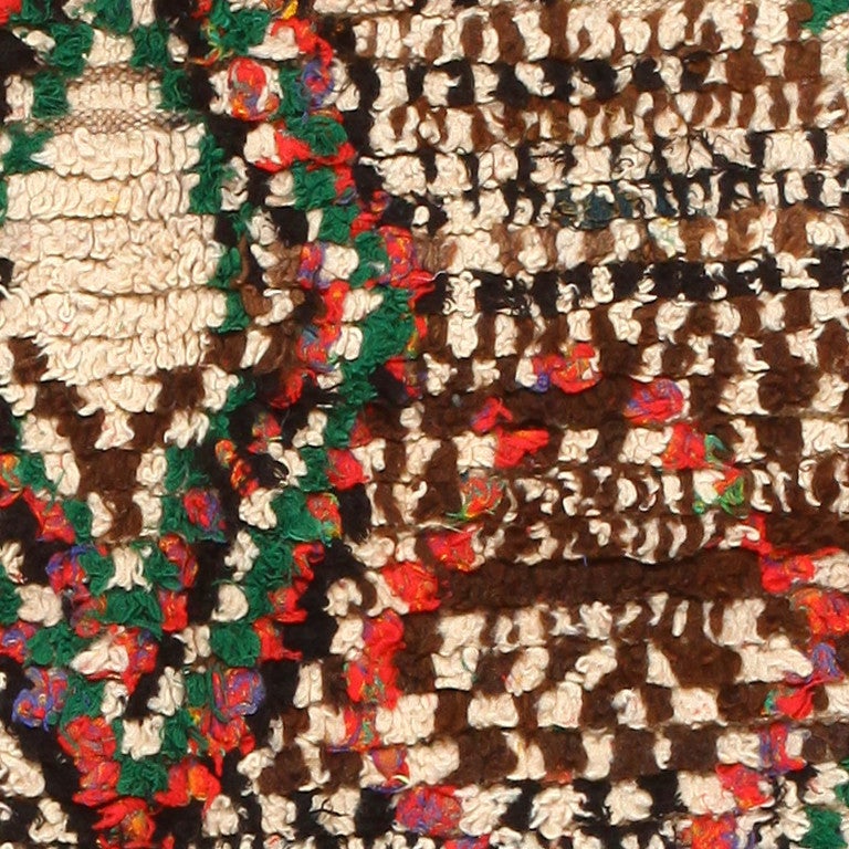 Vintage Moroccan rug, circa mid-20th century. This uniquely designed Vintage Moroccan rug would make an excellent addition to any interior living space. The beige and brown background on the rug is a great backdrop for the striking red, greens,